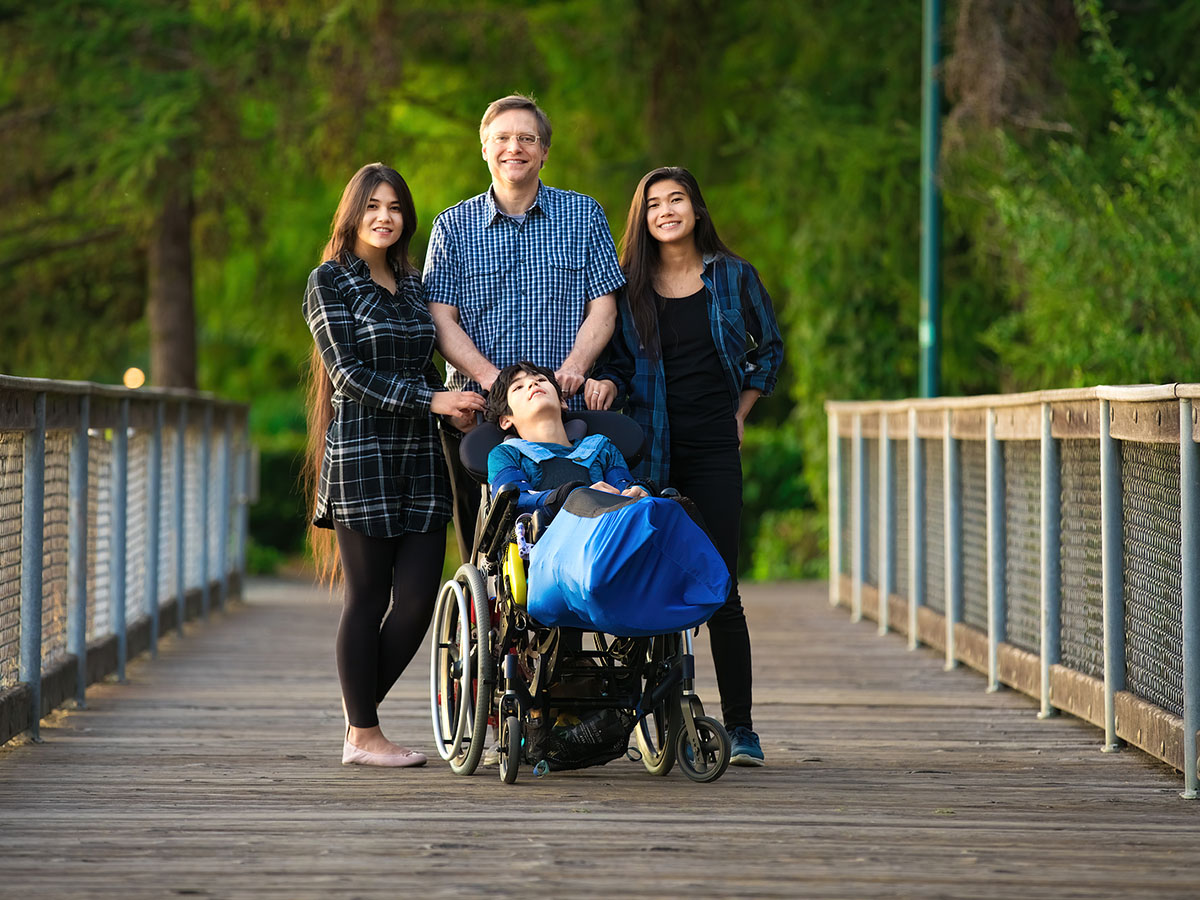 Caucasian Father Standing On Wooden Bridge At Park Outdoors With