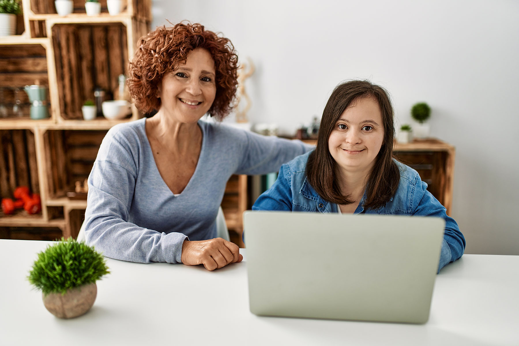 Mature mother and down syndrome daughter using computer laptop a